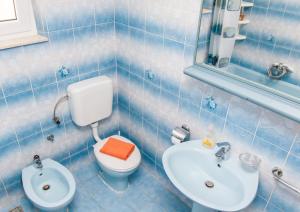 a blue tiled bathroom with a toilet and a sink at Nadalina Apartment in Kastel Stari +18 photos
