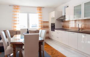 a kitchen and dining room with a table and chairs at Nadalina Apartment in Kastel Stari