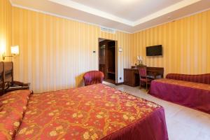a hotel room with two beds and a desk at Hotel Lido - Beach and Palace in Bolsena