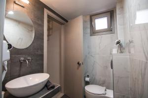 a bathroom with a sink and a toilet and a mirror at Elia Luxury Apartments in Stavros +38 photos