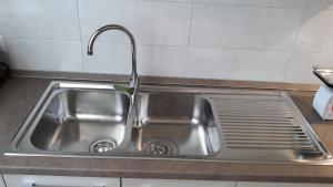 einem Spülbecken aus Edelstahl mit einem Wasserhahn in der Küche in der Unterkunft Lux Appartamento in Busso