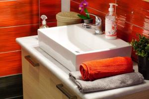 een wastafel met een oranje handdoek erop bij Anemona Apartment in Mithimna