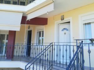 a front door of a house with a blue railing at Katerina's appartement in Nikiana