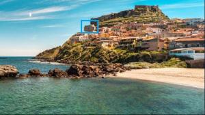 a beach with a town on top of a hill at La bella vista in Castelsardo