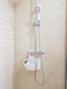 een douche met een douchekop in een badkamer bij Apartments Mobine in Metković