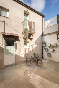 a patio with a table and chairs in front of a building at Il Cortiletto Hotel Maison in Tresnuraghes