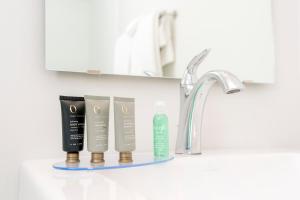 a bathroom sink with three products on a shelf at The Ellery in Northampton