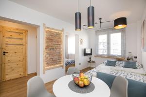 a living room with a bed and a table and chairs at Studio 49 Apartment in Ełk