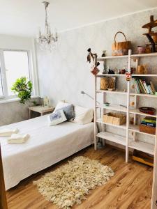 ein Schlafzimmer mit einem weißen Bett und einem Bücherregal in der Unterkunft Wind Rose apartment in Kuressaare