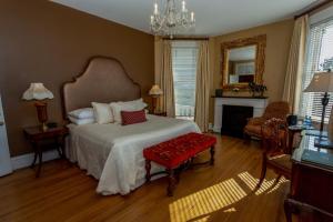 a bedroom with a large bed and a fireplace at Kehoe House, Historic Inns of Savannah Collection in Savannah