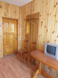 a room with a table and a tv on a wooden wall at Бирюза in Karolino-Buhaz