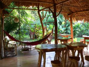 a hammock in a tent with tables and chairs at Blue Conga in Puerto Viejo