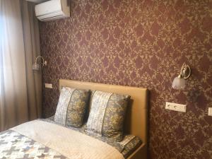 モスクワにあるChasy Brateevskaya Innの紫色の壁紙のベッド1台が備わるベッドルーム1室が備わります。