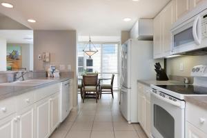 a kitchen with white appliances and a dining room at GullWing Beach Resort in Fort Myers Beach