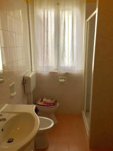 Un baño pequeño con inodoro y lavabo. en Villino Colussi, en Lignano Sabbiadoro 12 fotos más