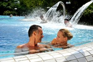 a man and a woman in a swimming pool at Hotel Pension Fortuna in Bad Bevensen