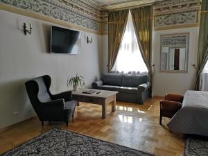 ein Wohnzimmer mit einem Sofa und einem Tisch in der Unterkunft Hotel Mikołaj in Krakau