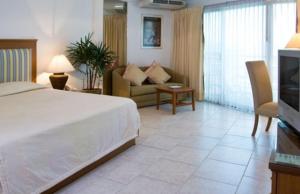 a bedroom with a bed and a couch and a television at Jomtien View Talay Studio Apartments in Jomtien Beach