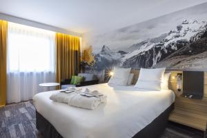 a hotel room with a large bed with a mountain mural at Novotel Annecy Centre in Annecy +221 photos