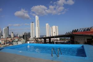 a swimming pool on top of a building with a city skyline at Hotel Caribe Panamá in Panama City