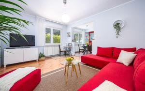 a living room with a red couch and a table at Apartment Cookie in Pula