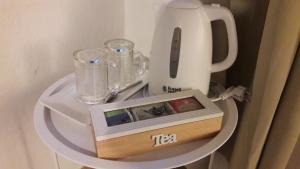 a table with a tea kettle and glasses on it at La Casa di Nina in La Maddalena