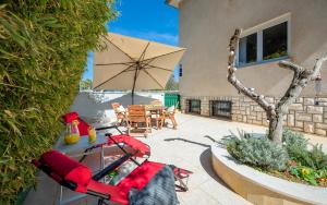 a patio with a table and chairs and an umbrella at Apartment Cookie in Pula