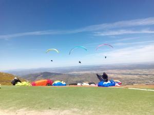 a group of people flying kites on top of a hill at El Mirador del Gato I y II in Mesegar de Corneja