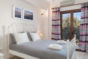 sypialnia z białym łóżkiem i balkonem w obiekcie Mampochi Guesthouse w Chanii