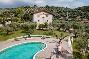 a man standing next to a swimming pool in front of a house at Agriturismo Casale Ré in Sonnino