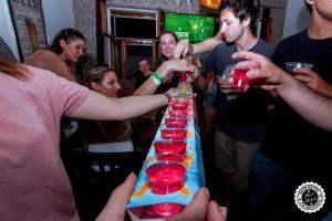 a group of people standing around a long table with drinks at Greg&Tom Beer House Hostel in Krakow