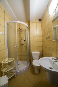 a bathroom with a shower and a toilet and a sink at Dom Wczasowy Barbara in Karwia