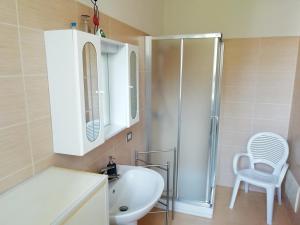 ein Badezimmer mit einem Waschbecken, einer Dusche und einem Stuhl in der Unterkunft Invorio La Corte in Invorio Inferiore