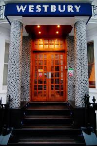 eine Eingangstür eines Gebäudes mit einer Treppe davor in der Unterkunft Westbury Hotel Kensington in London