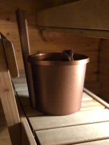 a brown bucket sitting on top of a wooden drawer at City Apartments Turku - 1 Bedroom Apartment with private sauna in Turku