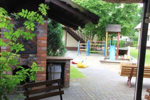 un horno de ladrillo al aire libre con un parque infantil en el fondo en Apartament w Domu Wypoczynkowym Zacisze en Stegna