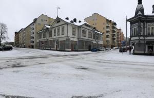 a snow covered street in a city with buildings at City Apartments Turku - 1 Bedroom Apartment with private sauna in Turku