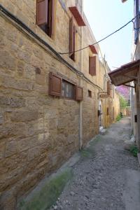 an alley in an old stone building with windows at RUSTIC SELF-INN in Rhodes Town