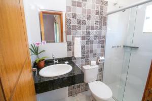 a bathroom with a toilet and a sink and a shower at Areia do Atlantico Hotel in Porto Seguro