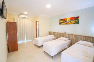 a hospital room with two beds and a tv at Areia do Atlantico Hotel in Porto Seguro