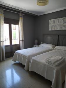 クエンカにあるDomus Cuencaのベッドルーム1室(ベッド2台、窓付)