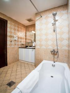 a bathroom with a white tub and a shower at ITLALA ALSHARQ FOR SERVICED APARTMENTs in Dammam