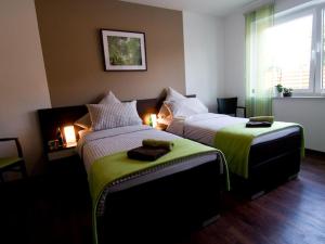 two beds in a hotel room with green sheets at Pension Dalinghaus in Vörden