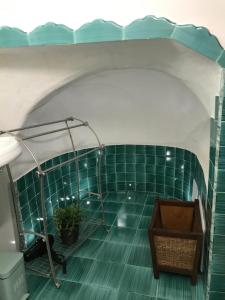 a bathroom with a green tiled floor and a table at Casa Cardi in Sperlonga