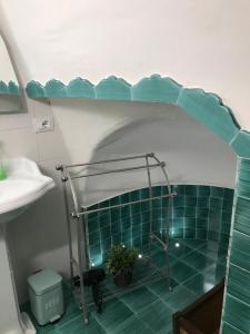 a bathroom with a sink and a shower with green tiles at Casa Cardi in Sperlonga