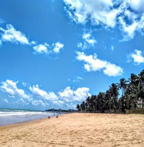 uma praia com palmeiras e um céu azul em Recanto do Mergulhão em Maceió