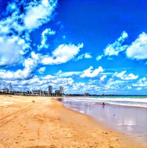 a sandy beach with a city in the background at Recanto do Mergulhão in Maceió