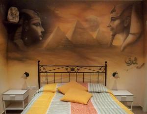 a bedroom with a bed and a painting on the wall at Il Mondo B&B in Fiumicino