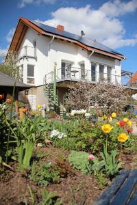 a house with a garden with flowers in front of it at Ferienwohnung Dr. Vera Schmidt in Kreischa