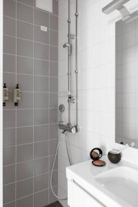 a white bathroom with a shower with a sink and a shower at Urban Trendy Nordic Living in Helsinki